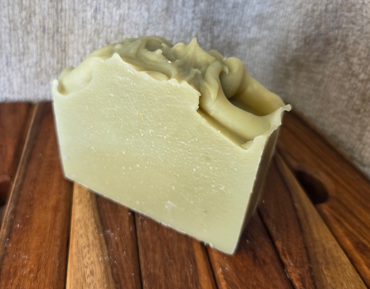 Pale celadon-green soap bar with a piped frosting-like top (alternate angle)