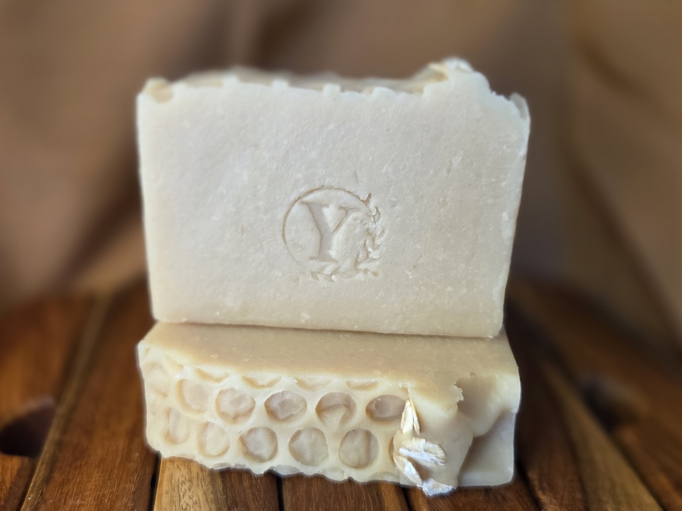 Cream soap bar stamped with a Y, stacked on a honeycomb-textured bar (alternate angle)