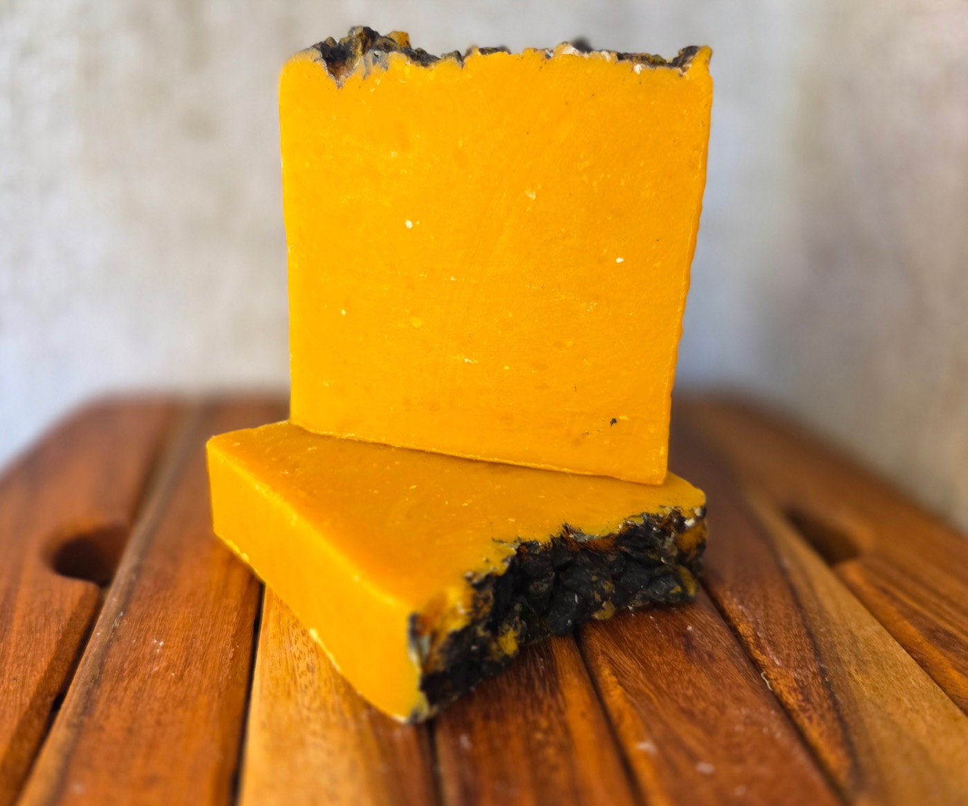 Two saffron-orange soap bars with dark crusted tops, stacked (alternate angle)