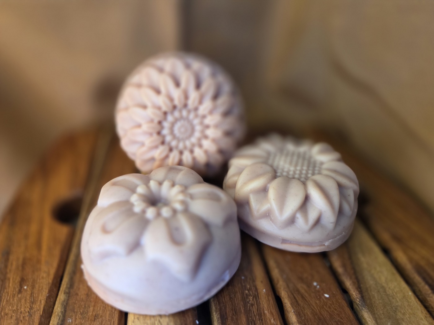 Dusty-rose soaps molded as chrysanthemum, sunflower, and daisy flowers (alternate angle)