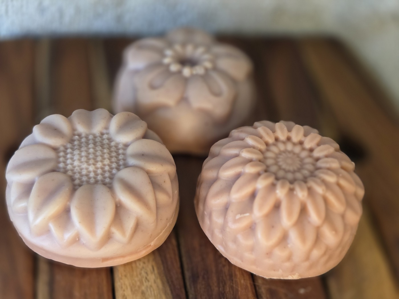 Dusty-rose soaps molded as chrysanthemum, sunflower, and daisy flowers (alternate angle)
