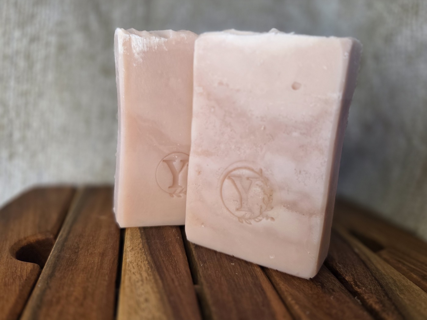 Two soft pink marbled soap bars stamped with a Y