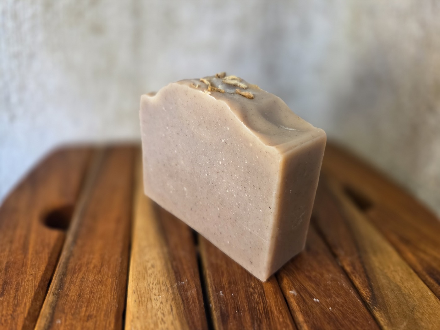 Blush-tan soap bar with oat flakes on a wavy top (alternate angle)