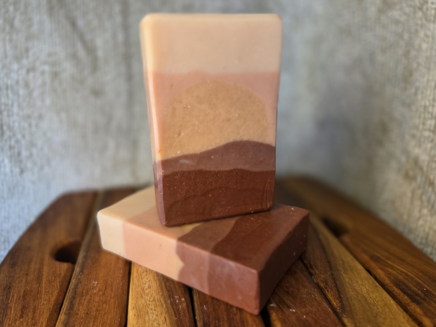 Layered soap bar with a sunset landscape design of cream, pink, and brown (alternate angle)